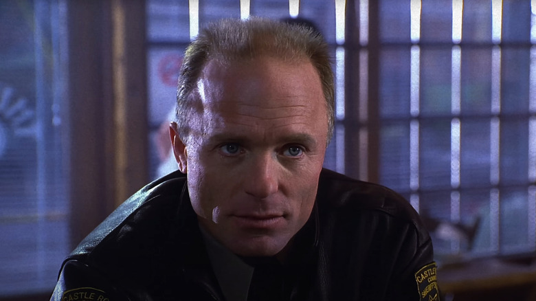 Alan in a police uniform in Needful Things