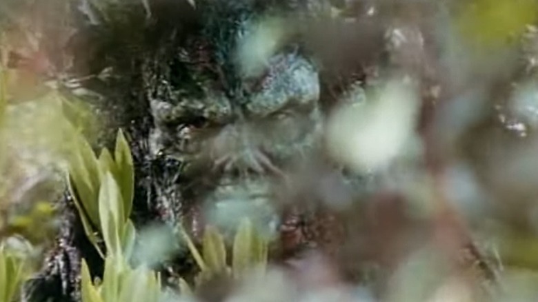 Swamp Thing staring sternly from behind branches