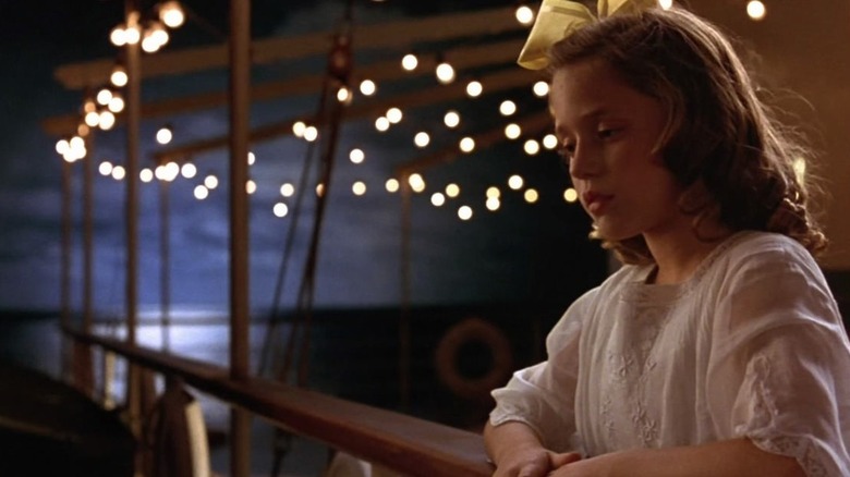 Girl looks over side of ship at night