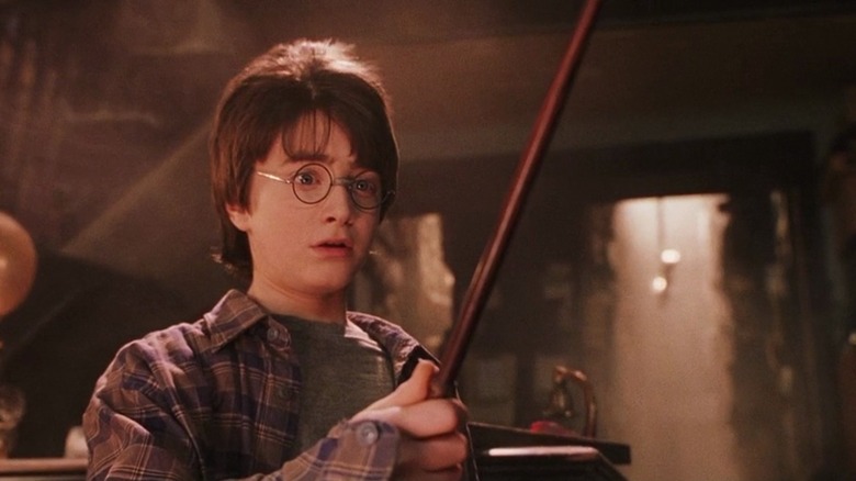 Boy with glasses holds wand