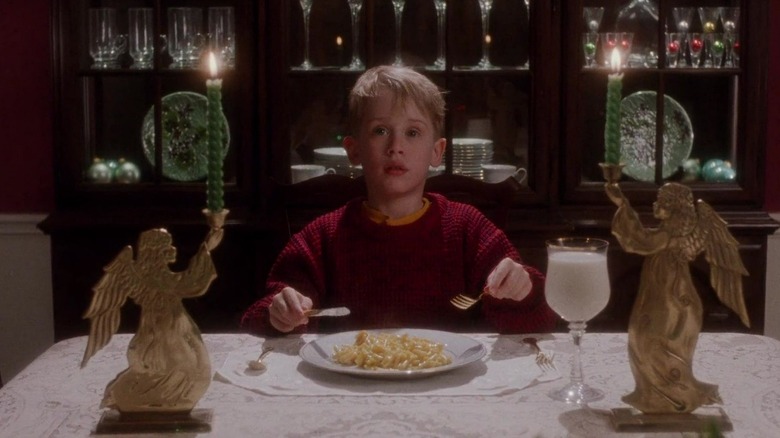 Boy sits alone at dinner table