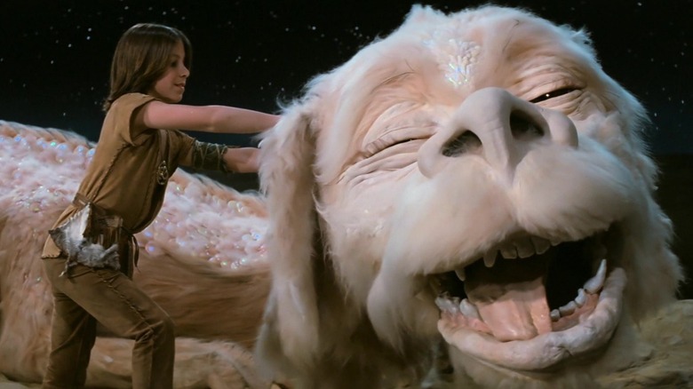 Boy scratches Falkor's ear