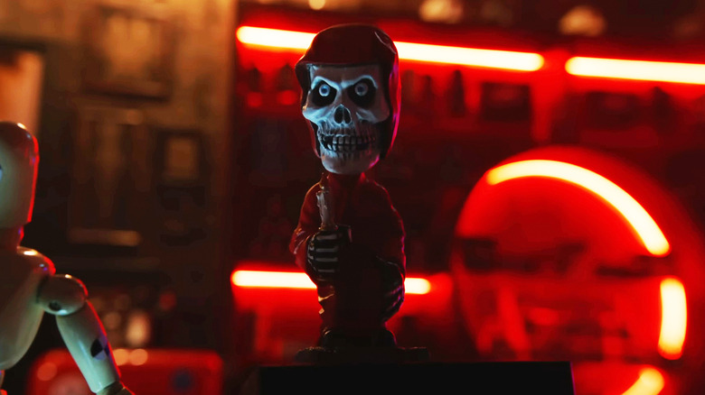 A grim reaper bobble head is shown on a counter in Final Destination Bloodlines