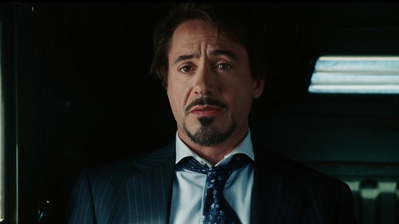 Tony Stark wearing a suit in a military vehicle in Iron Man