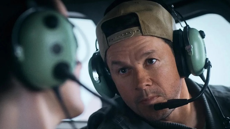 Mark Wahlberg as Daryl looking at Michelle Dockery's Madolyn in the cabin of the plane in Flight Risk