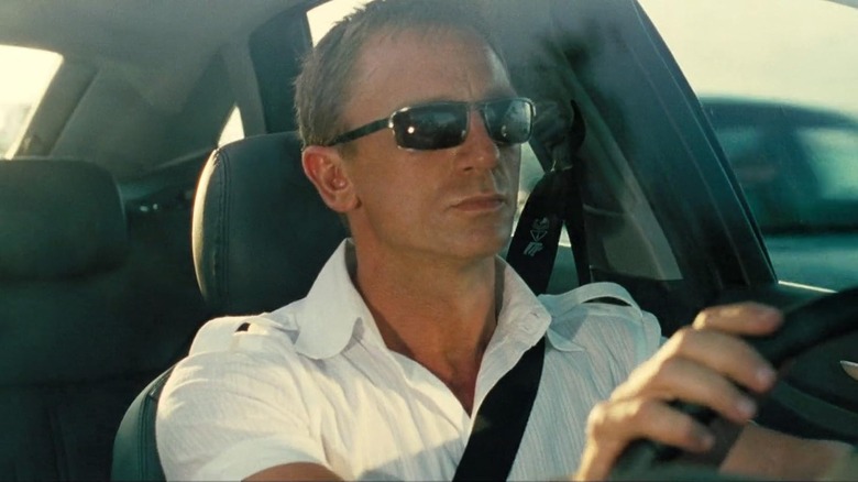 Daniel Craig as James Bond driving a car with sunglasses on in Casino Royale