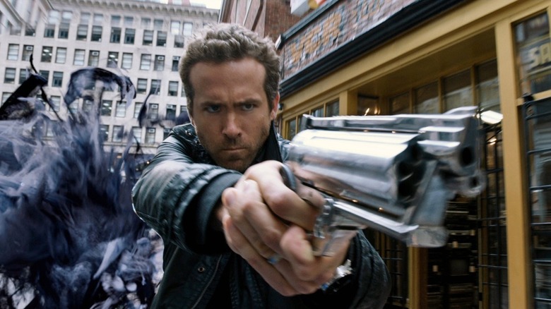 Nick Walker, a cloud of evil behind him, is firing a high-tech, supernatural gun in R.I.P.D.