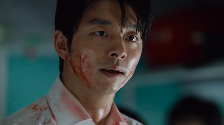 Gong Yoo como Seok Woo con sangre en el rostro y expresión de preocupación en el tren a Busan.