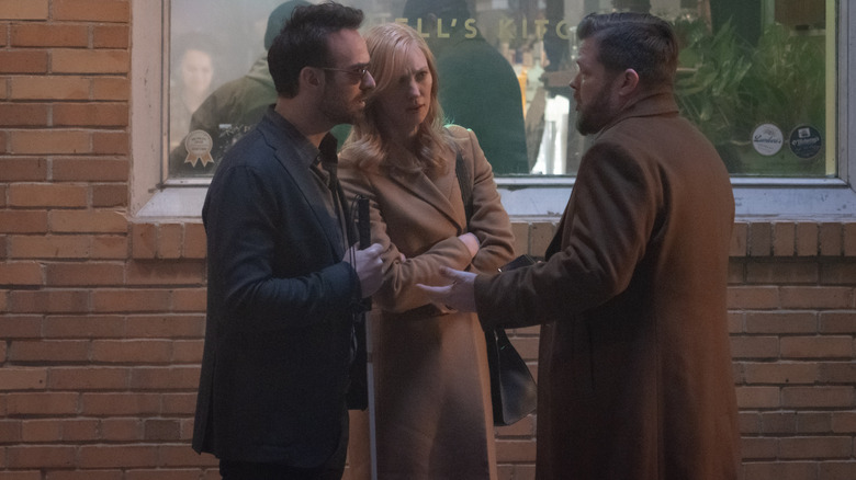 Charlie Cox as Matt Murdock, Deborah Ann Woll as Karen Page, and Elden Henson as Foggy Nelson talking animatedly on the streets of New York City in Daredevil: Born Again