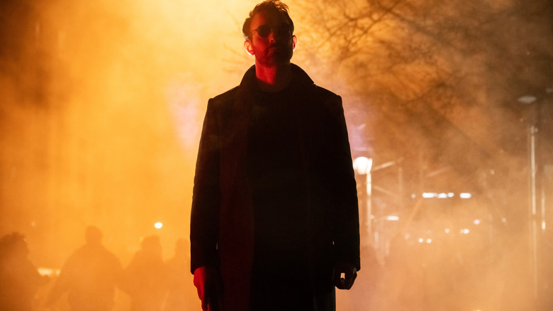 Charlie Cox as Matt Murdock standing on a fiery street in Daredevil: Born Again