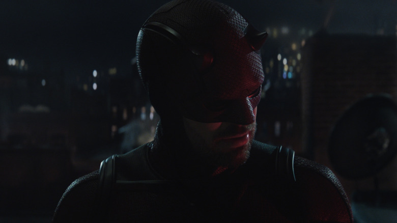 Charlie Cox suited up as Daredevil standing on a New York City roof in Daredevil: Born Again