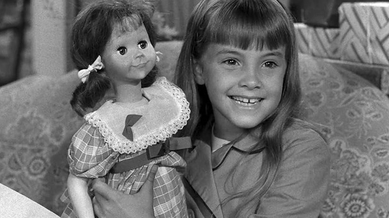 Young Christy proudly holds her creepy Talky Tina doll in the film 