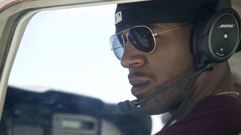 Scott Mescudi as Benny piloting a helicopter with sunglasses on in Need for Speed