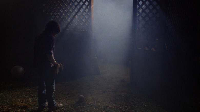 E.T. elliott looking at baseball outside shed