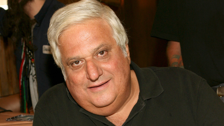 Michael Lerner leaning wearing black polo shirt