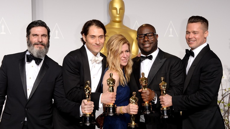 The filmmaking team behind 12 Years A Slave, including director Steve McQueen and Brad Pitt at right, holding their Oscars