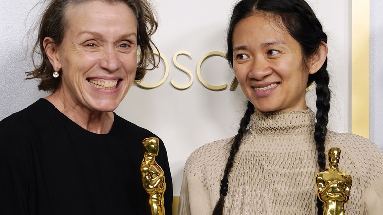 A grinning Frances McDormand and Chloe Zhao, holding their Oscars