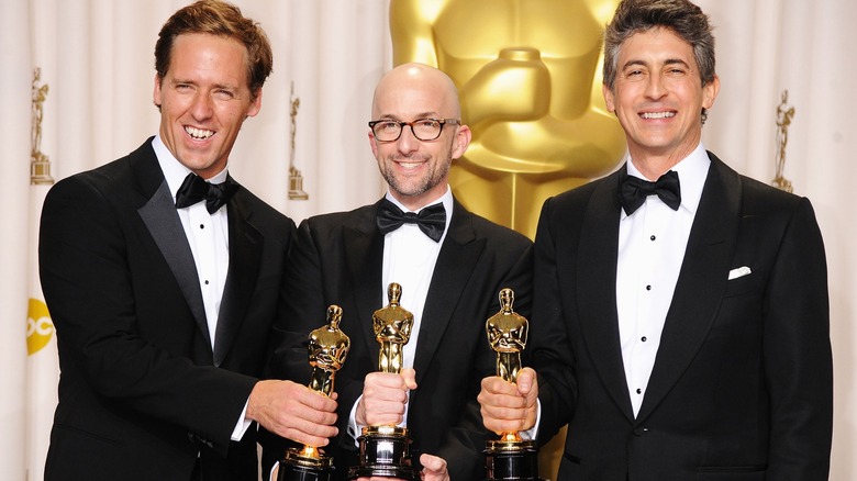 Nat Faxon, Jim Rash, and Alexander Payne holding their Oscars together backstage