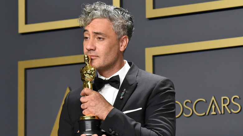 Taika Waititi kissing his Oscar