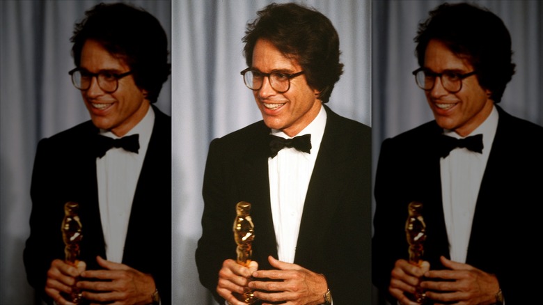 Warren Beatty, wearing glasses, holding his Oscar