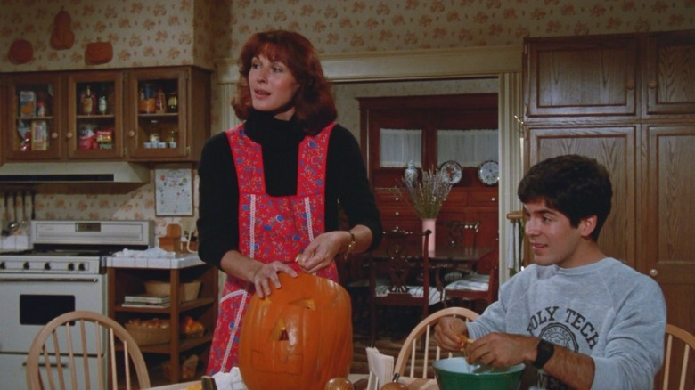 Jeannie carving a jack o lantern at a very 1970s kitchen table from Deadly Friend