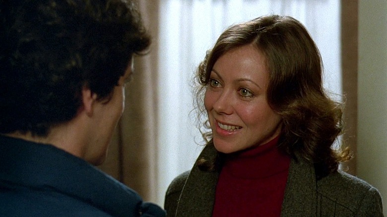 Alex Price, talking to David, smiling patiently, in An American Werewolf in London