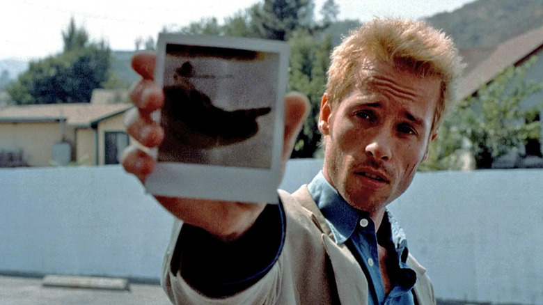 Leonard Shelby holding up a polaroid in Memento