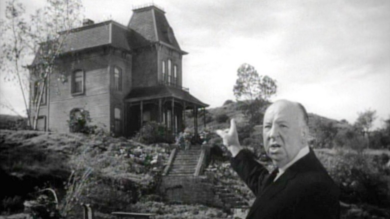 Alfred Hitchcock pointing to the Psycho house