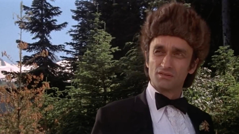 Stan, wearing a tux and fur hat in the woods, a scene from The Deer Hunter.