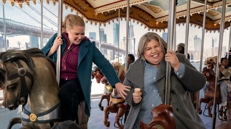 Amy Schumer's Lainy Newton rides a carousel alongside Urzila Carlson's Fallon in Kinda Pregnant.