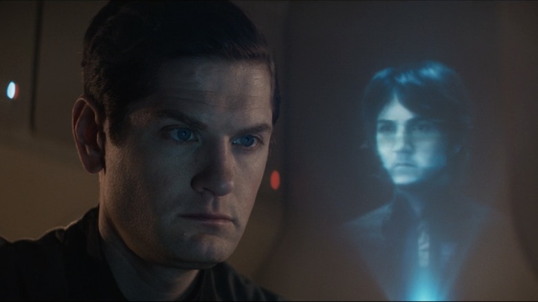 Syril stares angrily at a holoimage of Cassian Andor