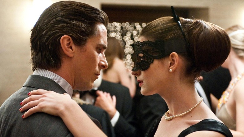 Christian Bale as Bruce Wayne and Anne Hathaway as Selina Kyle in The Dark Knight Rises