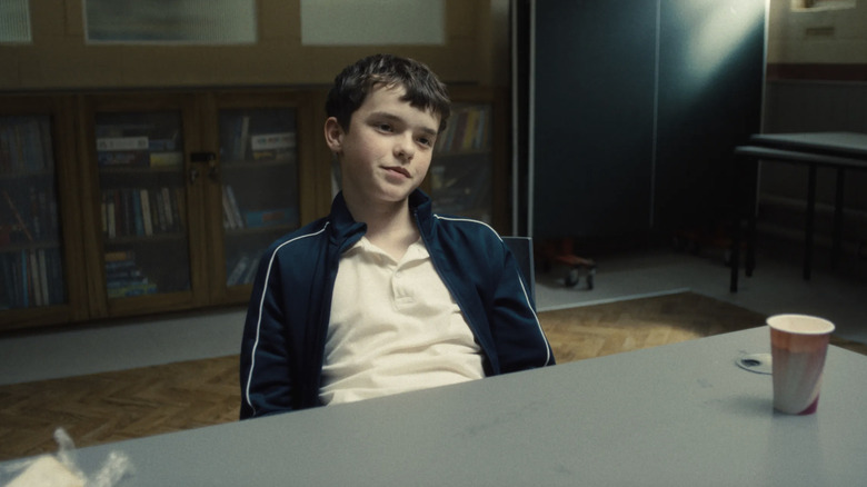 Owen Cooper as Jamie Miller sitting at a desk in Adolescence