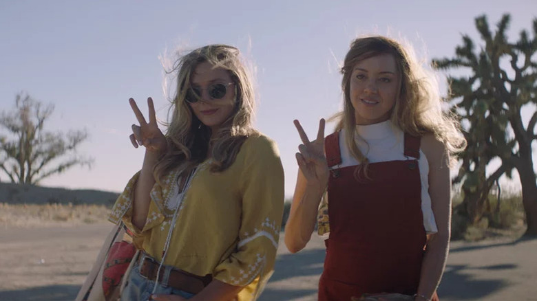 Elisabeth Olsen and Aubrey Plaza posing with peace sings in Ingrid Goes West