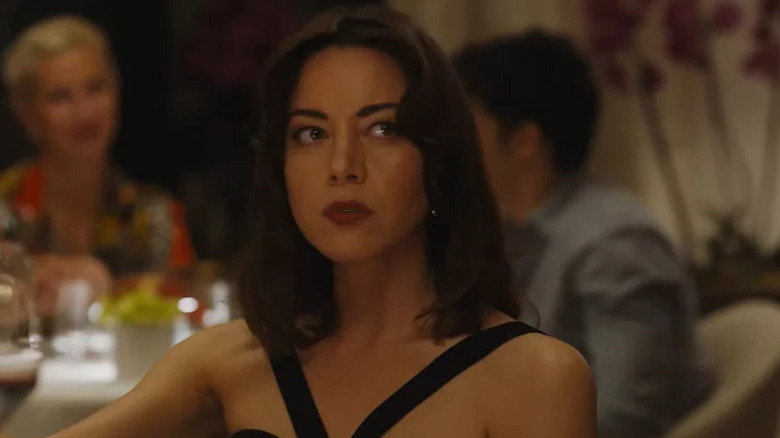 Aubrey Plaza looking suspicious at dinner table in The White Lotus