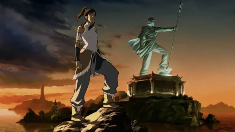 Avatar Korra de pie con una estatua de Aang en el fondo en la leyenda de Korra