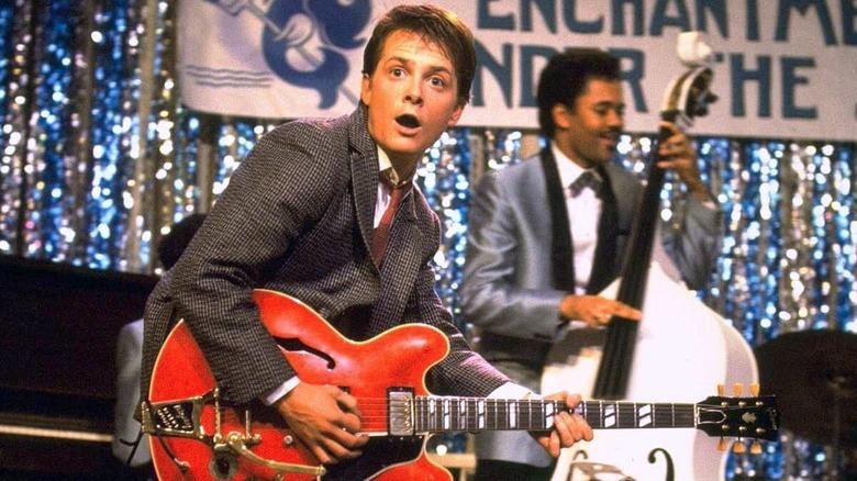 Marty McFly playing a red guitar at the dance