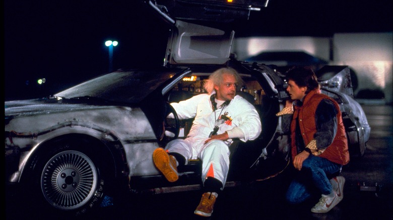 Doc Brown sits in the DeLorean time machine talking to Marty McFly