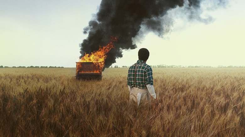 John David Washington as Boy Willie watches a piano burn in a wheat field in The Piano Lesson