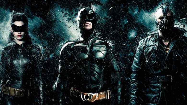 The Dark Knight Rises characters stand in the rain