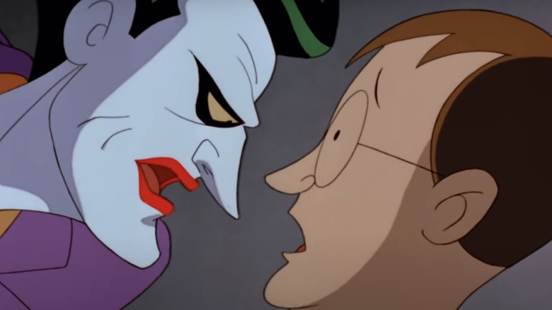 The Joker intimidates a man as he leans in close in Batman The Animated Series