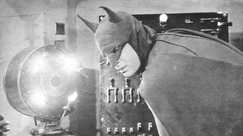 Batman leaning over an electrical control panel of some kind in Batman (1943)