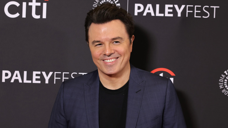 Seth MacFarlane wearing a dark blue suit jacket at a Family Guy event.