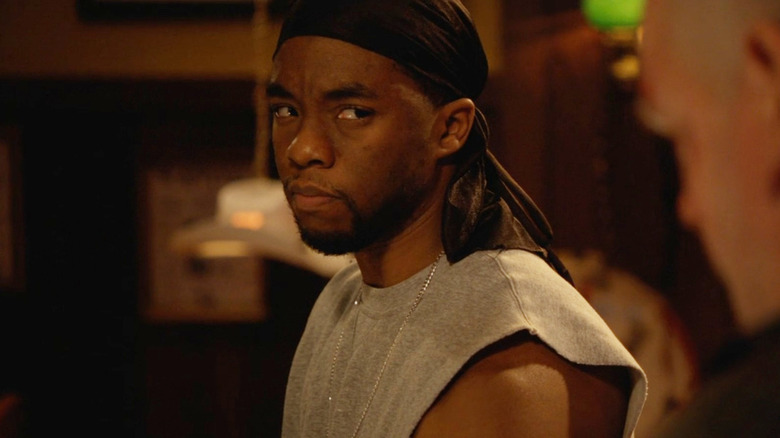 Chadwick Boseman as Flex Beeman stares intently at a character on an episode of the FX drama Justified