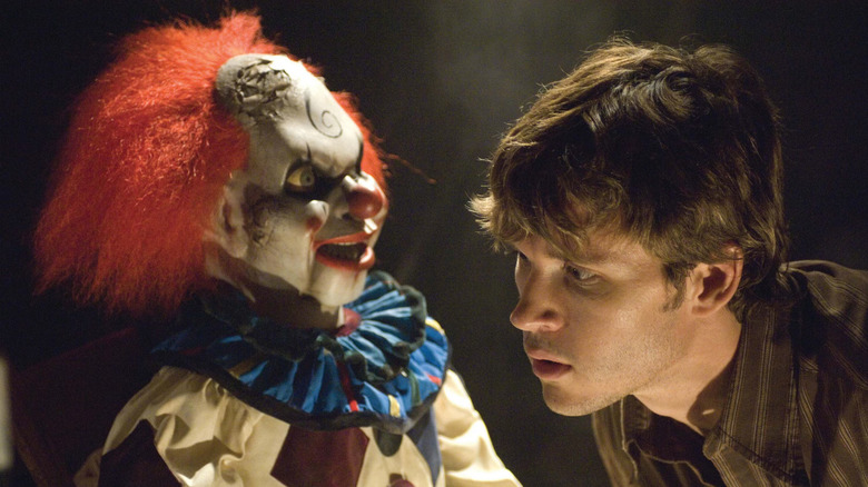 Jamie tries to listen if the clown doll is talking in Dead Silence