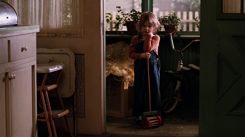 Drew Barrymore holding a toy mower in Altered States