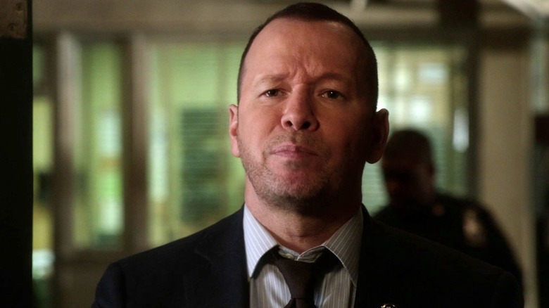 Donnie Wahlberg as Danny Reagan standing in a hallway in the Blue Bloods episode The Extra Mile