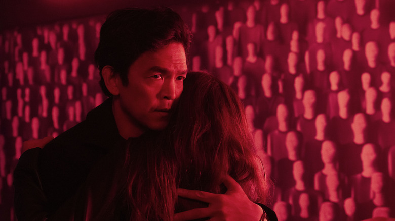 Curtis holding a woman close surrounded by red light in AfrAId