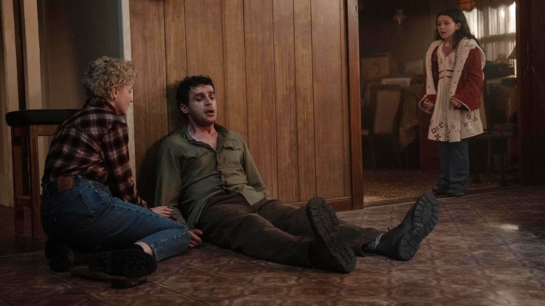 Julia Garner's Charlotte and Matlida Firth's Ginger look on at Christopher Abbott's Blake in concern in Wolf Man (2025)