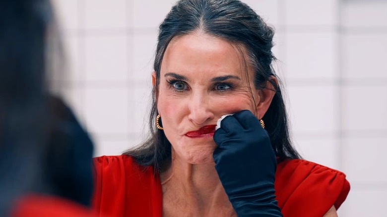 Demi Moore wipes at her face as Elisabeth Sparkle in The Substance